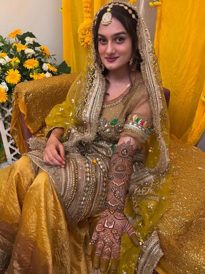The bride in her full mehendi ceremony attire. The henna is an essential part of the look, and it complements her outfit perfectly.