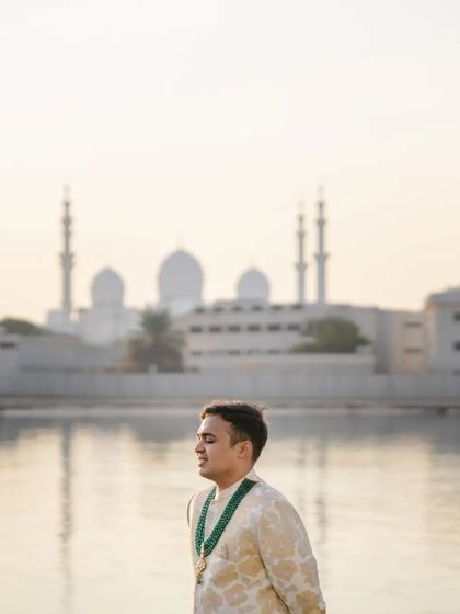 A serene portrait of Rishab with the Sheikh Zayed Grand Mosque in the background. The soft morning light and iconic setting create a truly breathtaking and meaningful image.