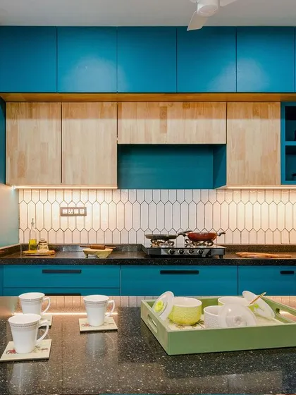 We believe functional spaces can also be joyful. This kitchen design uses a bold peacock blue, balanced with the warmth of rubberwood cabinets and a spacious black granite breakfast counter, creating an energetic yet practical heart of the home.