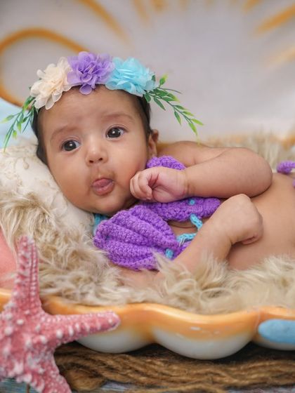 This little mermaid is sticking her tongue out. These playful, candid moments are often the favorites.