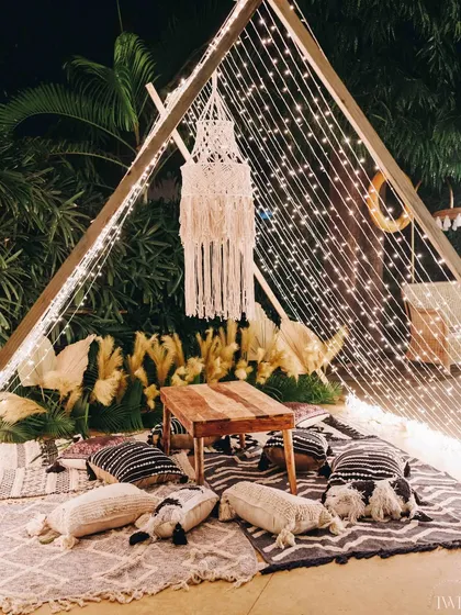 A cozy teepee seating nook, lit with fairy lights. We create these little corners for guests to have intimate conversations away from the main party.