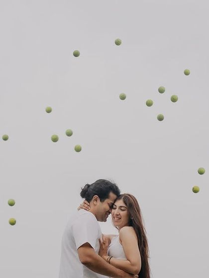 A creative shot with tennis balls seemingly frozen in the air around the couple. We love designing unique, dynamic portraits that are full of energy.