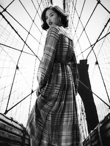 The graphic lines of the projected Brooklyn Bridge backdrop create a powerful visual contrast with the model's pose. This is a technique I teach for creating bold, high-impact fashion editorials.