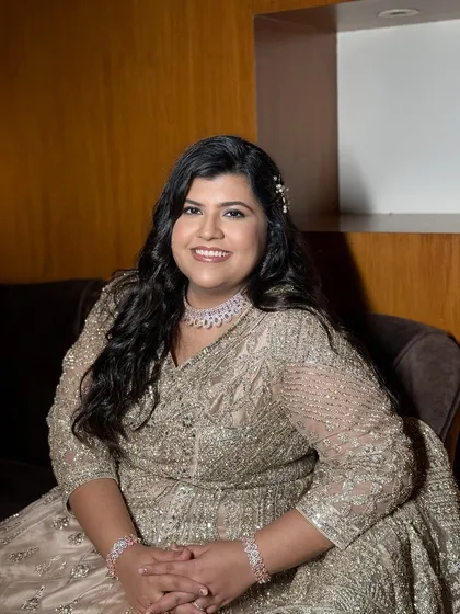 A full-length portrait, her smile radiant. The soft glam makeup is perfect for her elegant, shimmery gown.