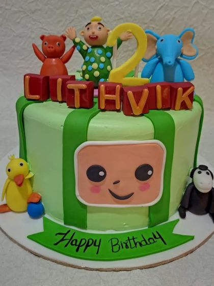 A Cocomelon cake perfect for a second birthday. This design features the iconic striped green melon and beloved characters like JJ and his animal friends.