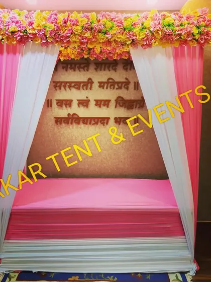 This is a pandal I designed for a Ganesh Chaturthi celebration. It features pink and white draping with a floral border and a backdrop with a Sanskrit shloka, creating a beautiful and sacred space for the idol.