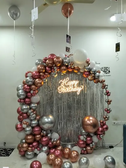 A wider angle of this luxe home birthday setup. The circular balloon garland creates a perfect frame for photos, with the neon sign and shimmer curtain adding a touch of glamour to the celebration.