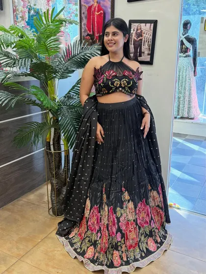 A closer look at our black floral lehenga. The halter neck blouse and the vibrant floral embroidery on the skirt make this a standout piece for any evening event.
