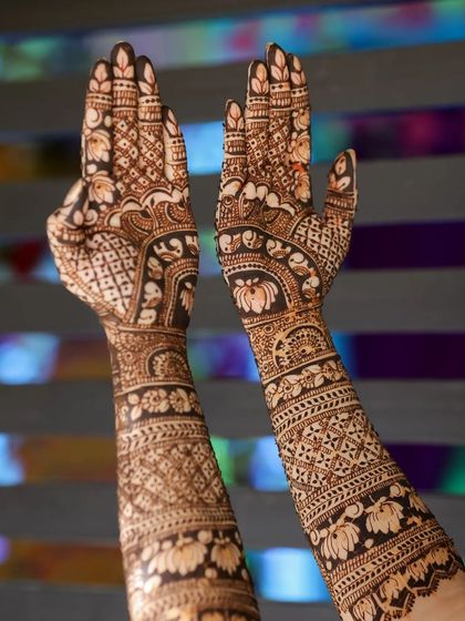 A stunning design with intricate lotus and geometric patterns, shown with hands raised.