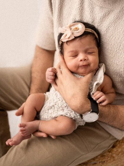 A father's hands provide the safest place for his newborn. This close-up shot highlights the gentle way a parent holds their baby, full of tenderness and protection.