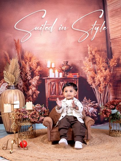 Suited in style, this little man is the picture of classic charm. The rustic, warm-toned backdrop with candles and pampas grass creates a cozy and sophisticated atmosphere.