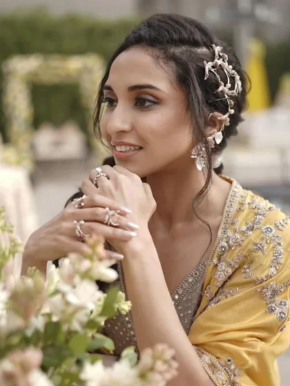 A soft and elegant look for a Haldi ceremony. The makeup is minimal and glowing, paired with a trendy bubble braid hairstyle adorned with a hair accessory.