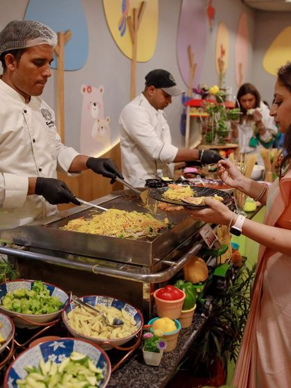 A guest is served a fresh plate from the live noodle counter. We ensure a seamless and enjoyable dining experience for everyone at the party.