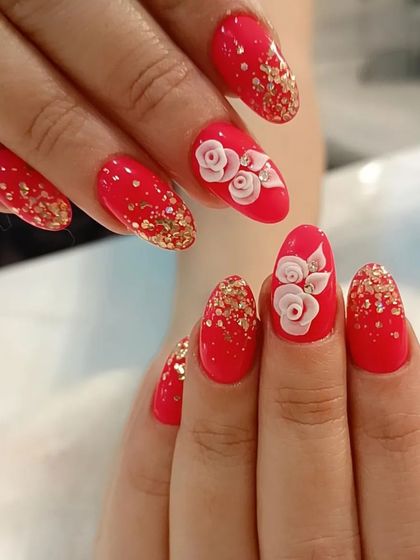 This bridal design features a bright red base with gold glitter accents and beautifully sculpted 3D roses on the ring fingers.