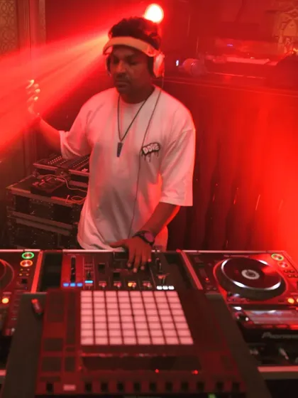 In the red glow of the club, fully immersed in the music. I use a combination of Pioneer CDJs and an Ableton Push controller for a dynamic live performance.