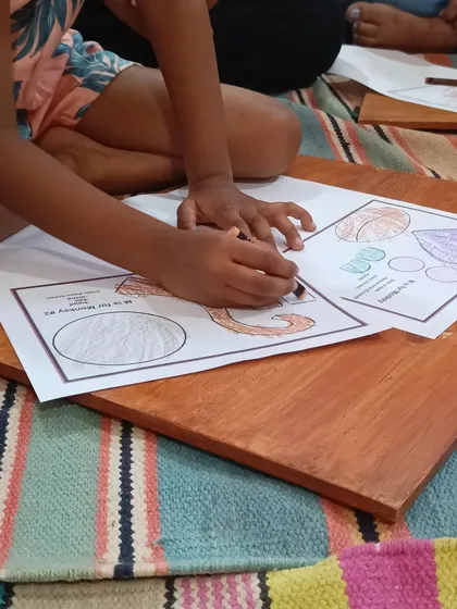 A close-up of a child coloring a picture of a monkey, showing their careful attention to detail.