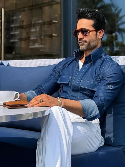 Casual elegance perfected. Our custom indigo denim shirt, paired with crisp white pleated trousers, redefines the weekend brunch or business-casual look. It’s a testament to how bespoke tailoring elevates even the most relaxed attire.