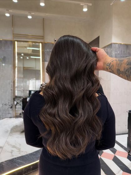 The final look of this ash brown transformation, styled into soft waves. The color is deep, rich, and full of shine.