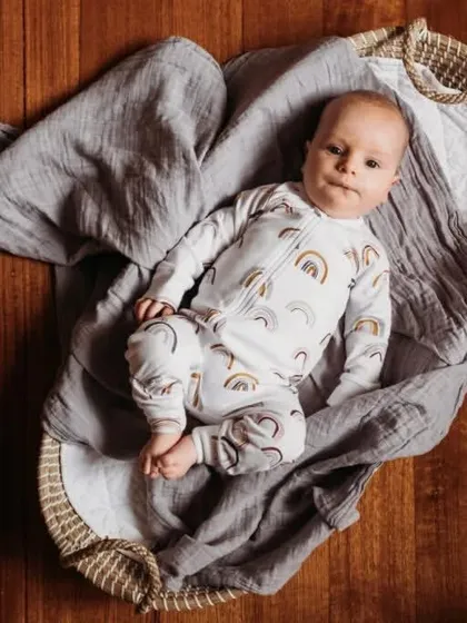 An alert newborn looking up from a soft basket. We capture both sleeping and awake moments to give you a full gallery of memories.