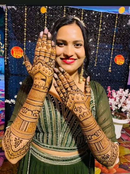 A smiling bride posing with her full bridal mehendi, a beautiful memory from her special day.