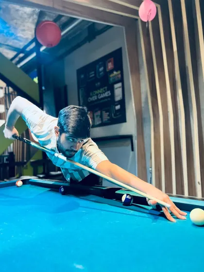 Here's a player deep in concentration during a game of pool. It's the perfect way to unwind and challenge yourself after a long week.