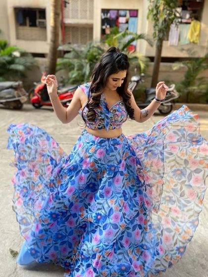 A fun, twirling shot of a blue floral organza lehenga. This lightweight and breezy outfit is perfect for a summer mehendi or a daytime event.
