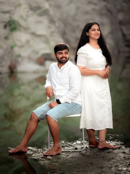 A serene pre-wedding portrait of a couple by the water, their matching white outfits adding to the calm and peaceful vibe.