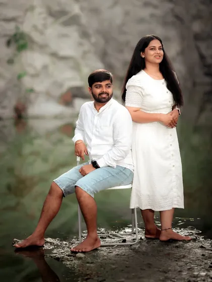 A serene pre-wedding portrait of a couple by the water, their matching white outfits adding to the calm and peaceful vibe.