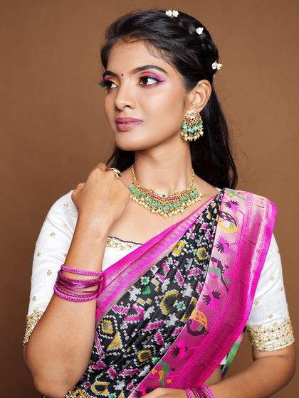 A modern twist on a traditional look, this model pairs our kundan and green bead choker with a unique saree drape.