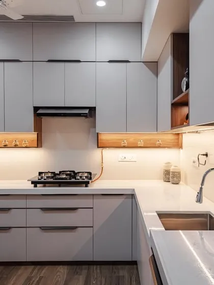 A wide view of the C-shaped modular kitchen at Kohinoor Square, Dadar. The light grey cabinets paired with wooden accents and flooring create a warm, contemporary, and inviting atmosphere.