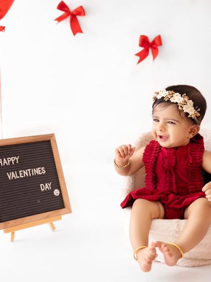 A big, happy laugh from this little valentine, sitting in a comfy chair next to a "Happy Valentines Day" sign.