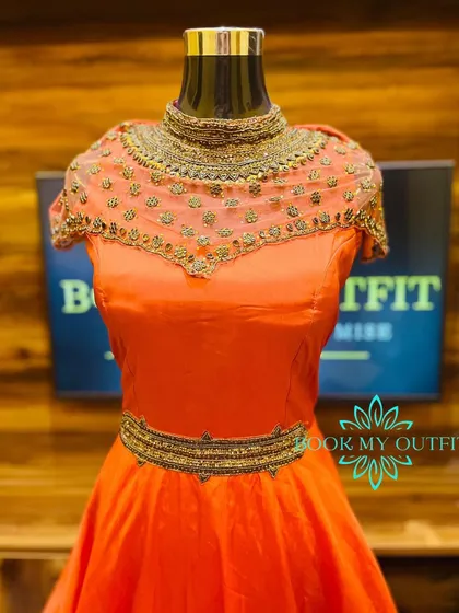 I also design and stitch Western wear, like this vibrant orange party gown. The highlight is the illusion neckline, which is hand-embroidered with beads and sequins, paired with a matching embellished belt to create a defined silhouette.