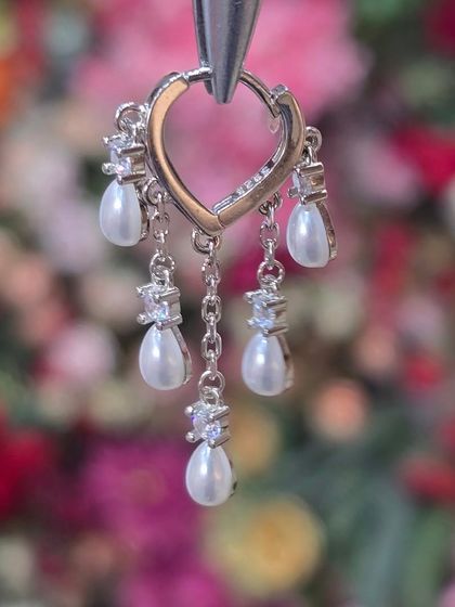 A beautiful heart-shaped hoop with dangling pearls and crystals, combining classic elegance with a touch of modern romance.