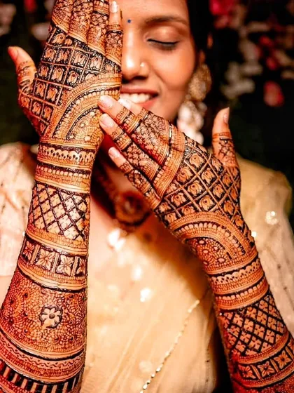 An artistic shot of the bride with her stained hands. The dark, crisp lines of the checkerboard pattern show the precision of the application and the quality of the stain.