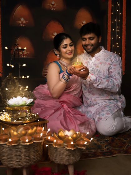 A loving couple celebrating Diwali together. The way they look at the diya they are holding creates a romantic and intimate atmosphere.