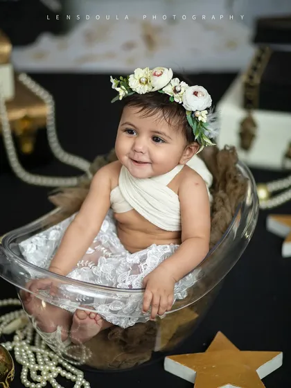 Pearls, lace, and a smile that lights up the room. This little fashionista is ready for her close-up in our glamorous 'Vogue' inspired sitter session.