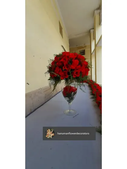 A close-up of one of the table centerpieces from the convocation event. The arrangement of red roses in a wine glass is a simple yet elegant detail that elevates the overall decor.