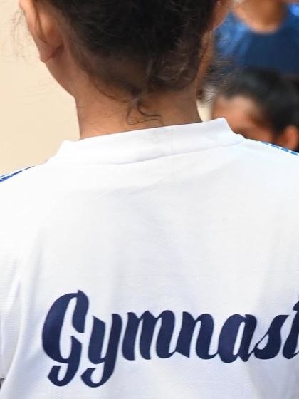 The back of our team shirt says it all: "Gymnast". It's a title our students wear with pride and dedication.