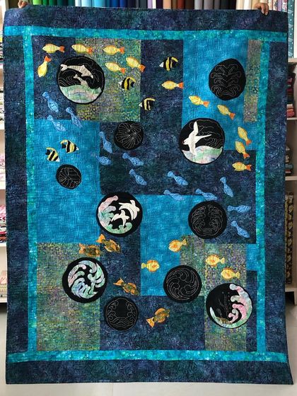 A stunning sea quilt featuring appliqué and sashiko techniques, which was featured at the 2019 Dubai Quilt Festival.