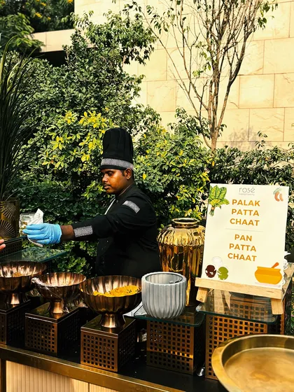 Our chef serves freshly made Palak Patta Chaat at an outdoor station. We bring a touch of luxury and perfection to every event with our exquisite gourmet cuisine and impeccable service.