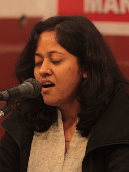A student lost in the melody of her bhajan, a moment of true musical meditation.