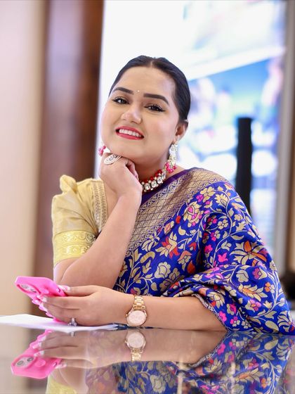 A cheerful moment during an event. The puff-sleeve blouse adds a retro touch to this timeless saree look, making it unique.