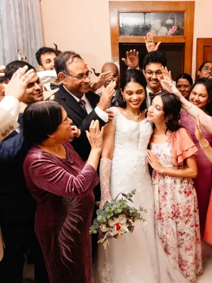 The bride's first look with her entire family. The love and blessings being showered upon her are palpable in this joyous, chaotic, and beautiful moment.