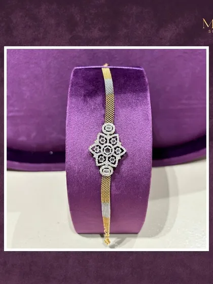 This two-tone gold bracelet features a beautiful floral diamond centerpiece. It's a versatile piece that can be worn alone or stacked with other bangles.