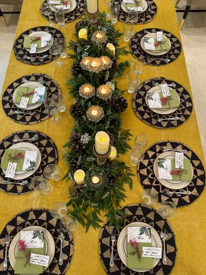 Beyond buffets, we craft exquisite sit-down dining experiences. This intimate dinner setup features a beautifully decorated table with lush greenery, candles, and personalized place settings, promising an evening of curated elegance.