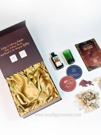 An exclusive and luxurious gift kit. This box features a satin lining and contains a curated selection of high-end items, including a miniature Jägermeister, shot glass, and custom coasters.