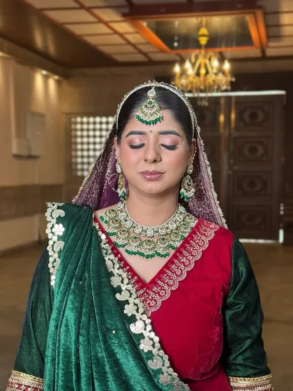 An eyes-closed shot to highlight the shimmery, soft-glam eye makeup that contrasts beautifully with the deep green and red attire.