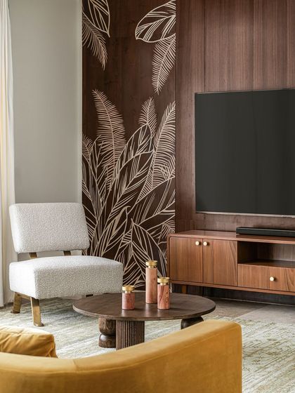 A close-up of the custom armchair and coffee table, showing the contrast of textures and materials. The design combines a modern silhouette with traditional carving, reflecting our "modern vintage" approach.