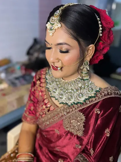 A side profile of Sheethal's reception look, showing off the intricate floral bun made with red roses.