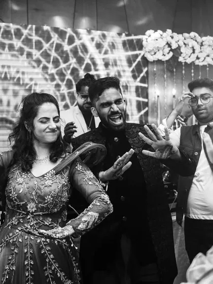 The couple dancing together with their friends, a moment of collective joy.